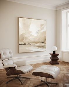 an empty living room with white chairs and a painting on the wall