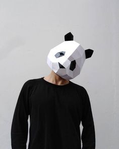 a man wearing a panda mask standing in front of a white wall with his hands on his hips