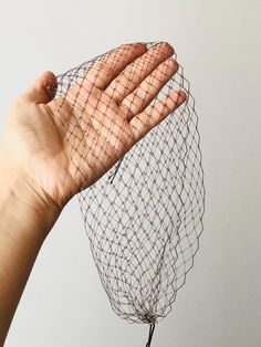 a hand is holding up a piece of wire