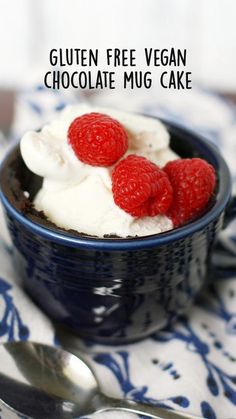 a blue bowl filled with ice cream and raspberries on top of a table