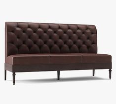 a brown leather couch sitting on top of a wooden frame