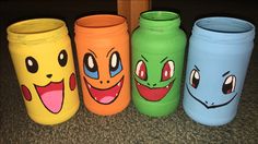 four different colored jars with faces painted on them