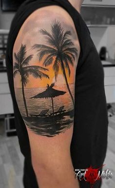 a man with a palm tree and umbrella tattoo on his arm is standing in front of the ocean