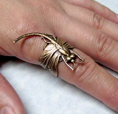 "Very beautiful dragonfly. Detail body and wings wrapped nicely around a heart band. Lovely for the dragonfly lovers. This ring is made from brass and is adjustable to fit onto a 6 to 9 ring size comfortably. Dragonfly ring is approximately 21mm wide x 37mm long (13/16\" x 1 7/16\"). Comfortable for day and evening wear. Other forest and woodland rings. https://www.etsy.com/shop/ranaway?section_id=10007337 You may choose to have this ring sized from 6 to 9, just leave ring size during check out. Adjustable Dragon Design Ring, Adjustable Dragon Design Jewelry Ring, Unique Adjustable Dragon Design Jewelry, Adjustable Unique Jewelry With Dragon Design, Unique Adjustable Open Butterfly Ring, Adjustable Metal Butterfly Ring, Steampunk Ring, Beautiful Dragonfly, Dragonfly Ring