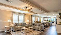 a living room filled with furniture and a ceiling fan