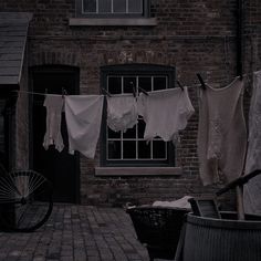 clothes hanging out to dry in front of a brick building