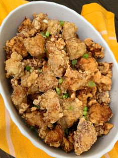 a white bowl filled with fried food on top of a yellow towel