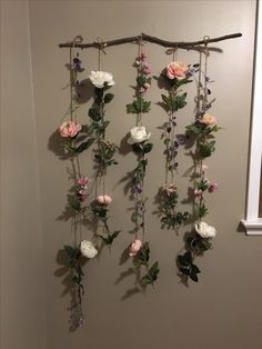 the flowers are hanging on the wall in front of the door and behind it is a branch