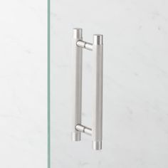 two stainless steel handles on a white marble wall