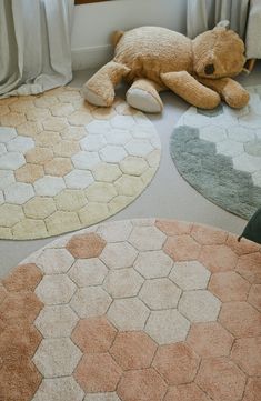 a teddy bear laying on the floor in front of some rugs