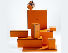 an orange box with a bow on top and several boxes stacked up in the shape of cubes