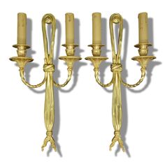 three golden candlesticks on a white background with one candle lit and the other turned off