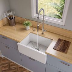 a kitchen sink sitting under a window next to a cutting board