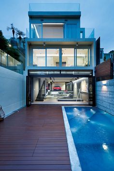 a house with a pool in front of it and stairs leading up to the upper level