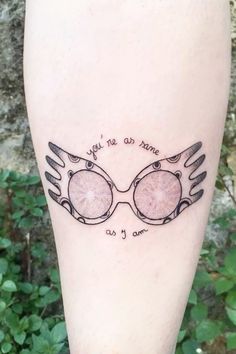 a tattoo on the leg of a person with glasses