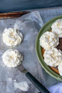 there is a cake with white frosting on the plate next to a knife and fork