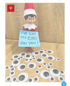 an elf is holding a sign that says i've got my eyes on you