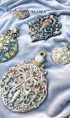 four different types of pendants on a blue cloth