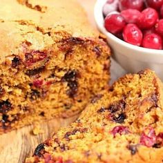 a loaf of fruit bread next to a bowl of cherries