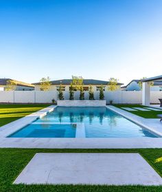 an empty swimming pool surrounded by grass