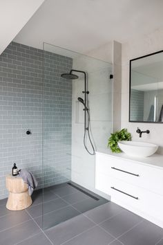 a modern bathroom with grey tile and white fixtures