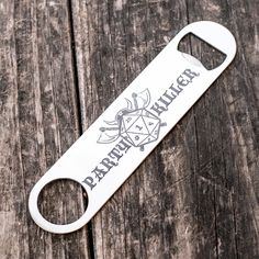 a bottle opener with the word papapima written on it sitting on top of a wooden table