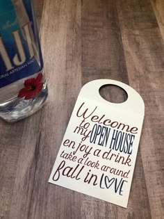 a door hanger that says welcome to the open house, enjoy a drink take a look around ball in love