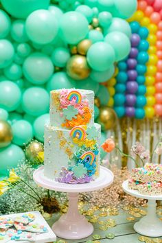 a birthday cake sitting on top of a table next to balloons and confetti