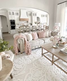 a living room filled with lots of furniture and flowers on top of a coffee table