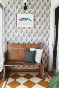 a wooden bench sitting in the middle of a room next to a door and window