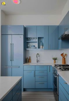 a kitchen with blue cabinets and white counter tops