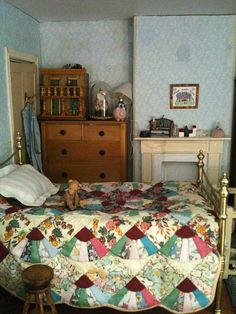 a bed room with a neatly made bed next to a dresser and chest of drawers