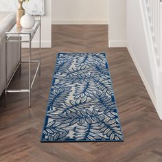 a blue and white area rug on the floor in a living room with hardwood floors