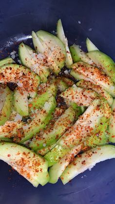 sliced cucumbers with seasoning in a blue bowl