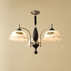 two light chandelier with white and black shades on the glass shade, hanging from a ceiling fixture