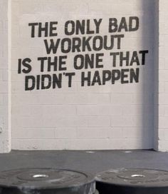 two black trash cans in front of a white wall with the words, the only bad workout is the one that didn't happen