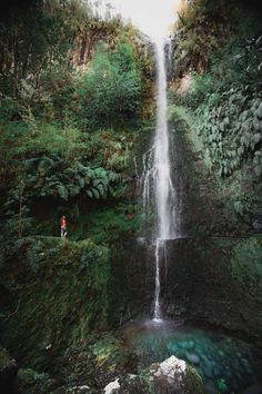 a person standing in front of a waterfall