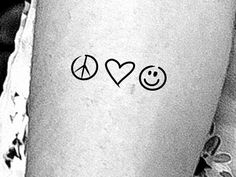 a woman's leg with two peace signs and a heart on the left side