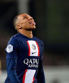 a close up of a soccer player with his eyes closed and mouth wide open in the air