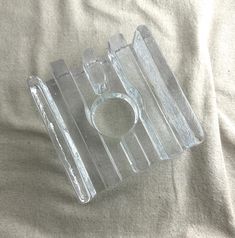 a clear object sitting on top of a white sheet