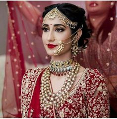 a woman in a red and gold bridal outfit