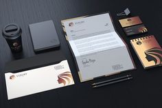 the stationery is neatly organized and ready to be used for business cards, stationary notepads, coffee cup, pen and paper