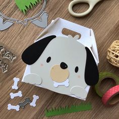 a dog shaped box sitting on top of a wooden table next to scissors and other items