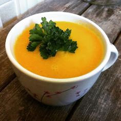 a white bowl filled with soup on top of a wooden table