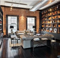 a living room filled with lots of furniture and bookshelves next to a window