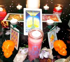 candles and cards on a glass table surrounded by other items