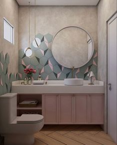 a bathroom with pink and green tiles on the walls, a round mirror above the toilet