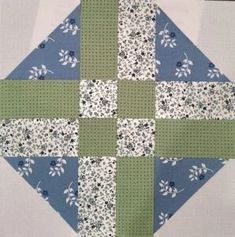 a blue and green patchwork quilt with white flowers on it's center piece