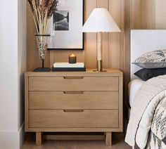 a bedroom with a bed, nightstand and pictures on the wall