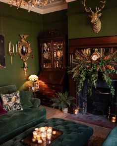 a living room filled with green couches and candles